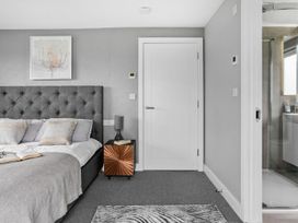 A bedroom with a bed and an ensuite shower at Huxham View & Annex in Kingsteignton