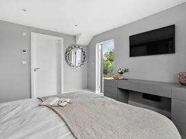 A bedroom with a bed and a TV at Huxham View & Annex in Kingsteignton