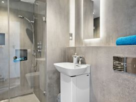 A bathroom with a shower, sink, and towel at Huxham View & Annex in Kingsteignton