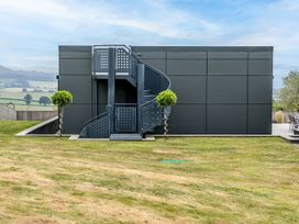 A building with a staircase in the garden at Huxham View & Annex Kingsteignton