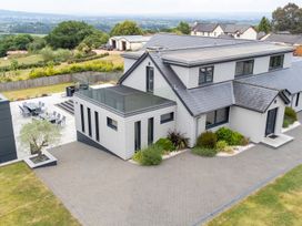 An outdoor view of a house with a garden and seating area at Huxham View & Annex in Kingsteignton