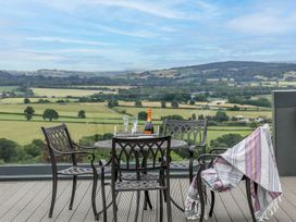 An outdoor seating area with a table and chairs overlooking a scenic view at Huxham View & Annex in Kingsteignton