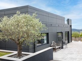 An outdoor area featuring a building, tree, and bench at Huxham View & Annex in Kingsteignton
