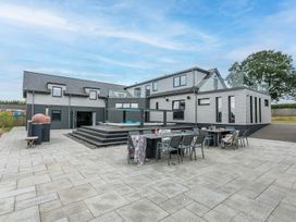 An outdoor patio with a dining table and chairs at Huxham View & Annex in Kingsteignton