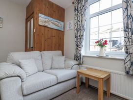 A living room with a sofa and table at Chapel Cottage in Filey