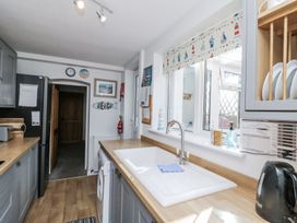 A kitchen with a sink and fridge at Chapel Cottage in Filey
