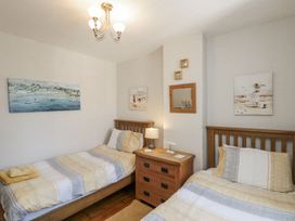 A bedroom with two single beds and a bedside table at Chapel Cottage in Filey