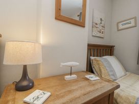 A bedroom with a bedside table and lamp at Chapel Cottage in Filey