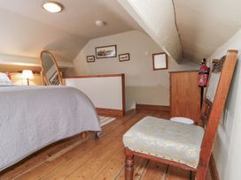 A bedroom with a bed and a mirror at Chapel Cottage in Filey