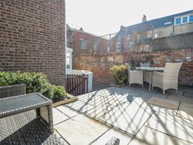 A garden with seating area and brick wall at Chapel Cottage in Filey