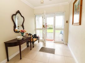 A hallway with a console table, mirror, and flowers at Cross Beg, Kilmihil, County Clare