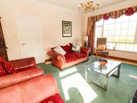 A living room with a sofa, chair, and coffee table at Cross Beg, Kilmihil, County Clare