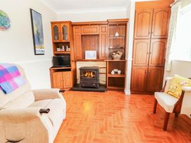 A living room with a fireplace and television at Cross Beg in Kilmihil, County Clare