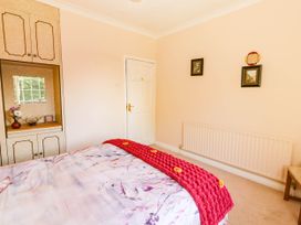 A bedroom with a bed, wardrobe, and wall art at Cross Beg, Kilmihil, County Clare