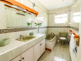 A bathroom with a bath tub, sink, and toilet at Cross Beg in Kilmihil, County Clare