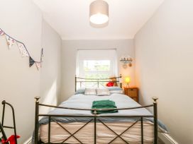A bedroom with a bed and window at Derwen-Las in Penmaenmawr