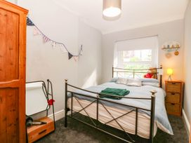 A bedroom with a bed and wardrobe at Derwen-Las in Penmaenmawr