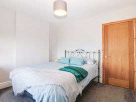 A bedroom with a bed and a door at Derwen-Las in Penmaenmawr