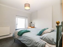 A bedroom with a bed and window at Derwen-Las in Penmaenmawr