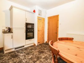 A kitchen with a dining table and chairs at Derwen-Las in Penmaenmawr
