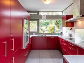 A kitchen with red cabinets and window at Two Hoots Littleworth