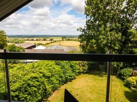 A view of fields and trees from a balcony at Two Hoots Littleworth