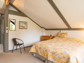 A bedroom with a bed, nightstand, and chair at Two Hoots Littleworth