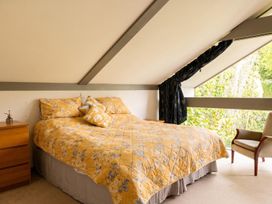 A bedroom with a bed and chair at Two Hoots Littleworth