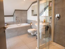 A bathroom with a bathtub, shower, and sink at Two Hoots Littleworth