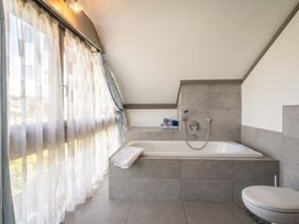 A bathroom with a bathtub and towels at Two Hoots Littleworth