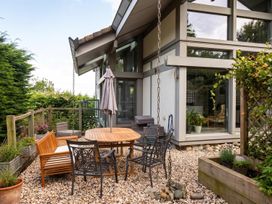 A garden with table and chairs under an umbrella at Two Hoots Littleworth