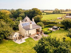 An outdoor view of a house with solar panels and a hot tub in the garden