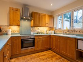A kitchen with wooden cabinets and appliances at The Old Barn in Manchester