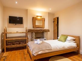 A bedroom with a bed, television, and shelving unit at The Old Barn in Manchester