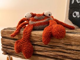 A crochet crab on a wooden surface