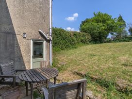 A garden with a wooden table and chairs outside a house at The Old Barn in Manchester
