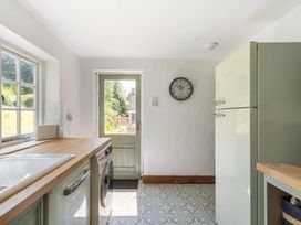 A kitchen with a fridge, sink, door, and washing machine at The Old Barn in Manchester