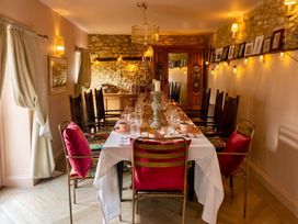 A dining room with a long table set for dinner at The Old Barn in Manchester