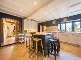 A kitchen with a large island and bar stools at The Old Barn in Manchester