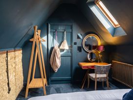 A bedroom with a table and chair near a window at The Old Barn in Manchester