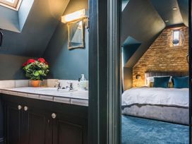 A bathroom with sink and mirror leading to a bedroom at The Old Barn in Manchester