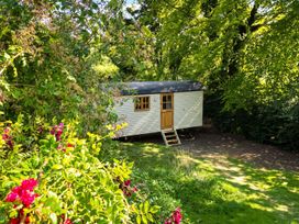 A mobile home with steps in a garden surrounded by plants and trees