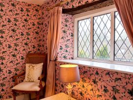 A sitting room with a chair and window at The Old Barn in Manchester