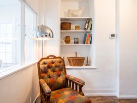 A living room with a chair and books on a shelf at a property in unspecified location