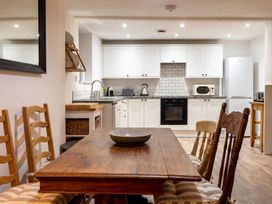 A kitchen with a wooden table and chairs at The Old Barn in Manchester