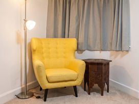 A living room with a yellow chair and side table at 