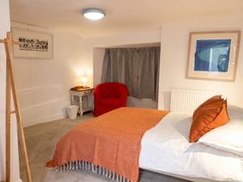 A bedroom with a bed and a red chair at The Old Barn in Manchester