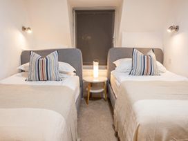 A bedroom with two beds and a lamp on a nightstand at 