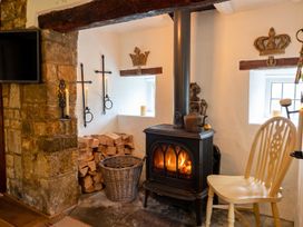 A living room with a fireplace and wood storage at The Old Barn in Manchester