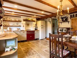 A kitchen with dining table and appliances at The Old Barn in Manchester